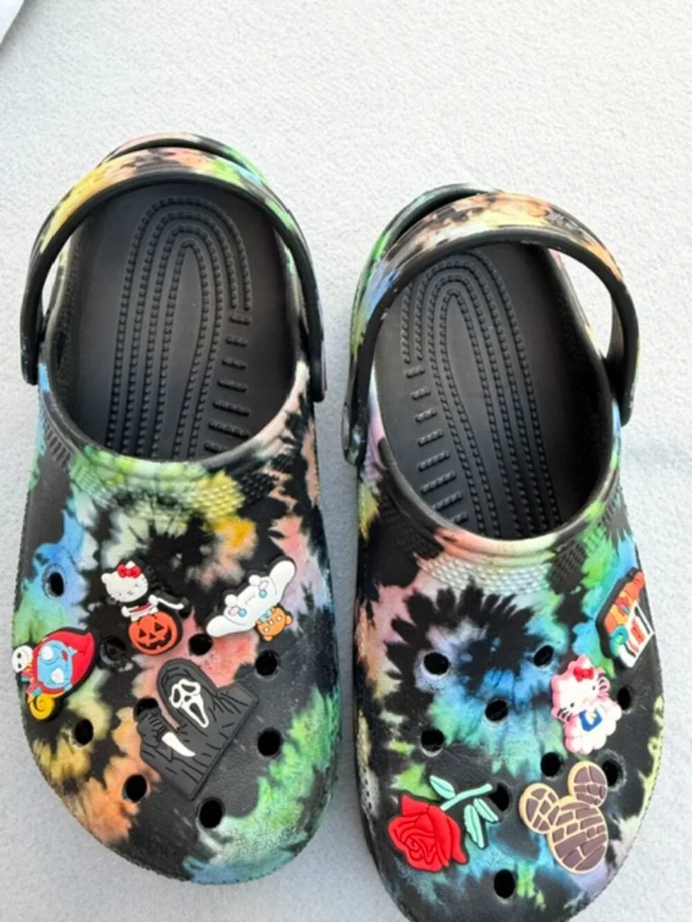 The product is a pair of Crocs Kids Size J 3 Black Tie-Dye Classic Clog Sandals
